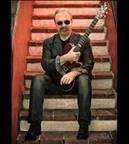 A person sitting on a staircase holding a guitar

Description automatically generated with low confidence